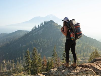 man in black jacket and black pants wearing black backpack standing on rocky mountain during daytime