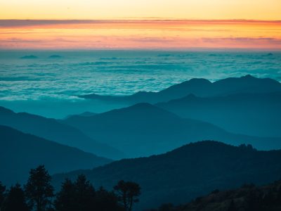 silhouette of trees and mountains during sunset