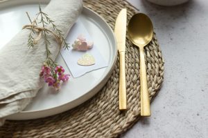 a white plate topped with a gold fork and knife
